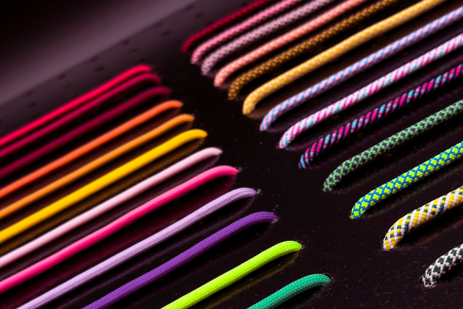 Colorful hat ropes arranged in a pattern on a dark surface