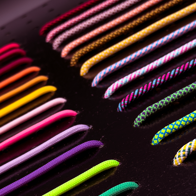 Colorful hat ropes arranged in a pattern on a dark surface